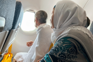 Pèlerins en ihram dans un avion en direction de La Mecque pour l’Omra – image utilisée par Colibri Voyage pour ses voyages Omra depuis le Maroc.