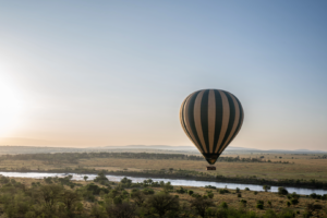 Montgolfière survolant la savane africaine au lever du soleil, expérience emblématique lors d’un safari, d’un voyage ou d’un voyage organisé au Kenya ou en Tanzanie.