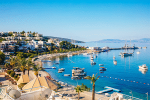 Photo panoramique de Bodrum en Turquie pour un voyage organisé, montrant la baie, les maisons blanches, les bateaux et la mer turquoise sous un ciel bleu.