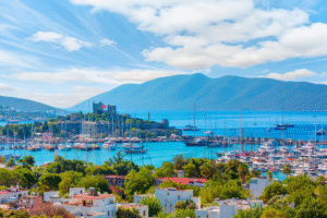 Photo panoramique de Bodrum en Turquie pour un voyage organisé avec la marina, la forteresse de Bodrum, les yachts et la mer turquoise sous un ciel bleu.