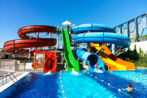 Parc aquatique en Turquie avec toboggans colorés se jetant dans une piscine, idéal pour un voyage organisé en famille.