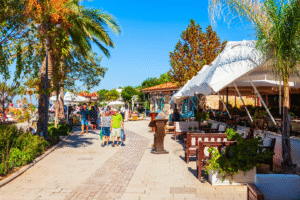 Promenade en bord de mer en Turquie avec palmiers, cafés et touristes pendant un voyage organisé.