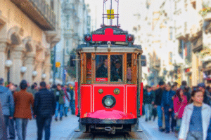Tramway rouge historique de la rue Istiklal à Istanbul entouré de foule, symbole d'un voyage organisé ou d'un voyage en Turquie.
