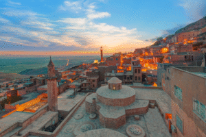 Ville historique en terrasse de Turquie au coucher du soleil, avec minarets et maisons en pierre, idéale pour un voyage organisé ou un voyage de découverte.